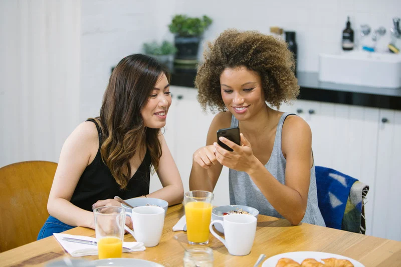 Desk with leather desk pad, walnut desk organizer, wireless keyboard and mouse, and porcelain mug.